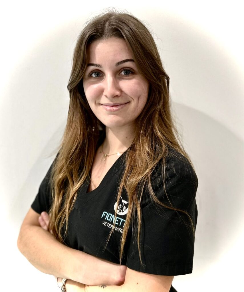Mujer con uniforme de veterinaria sonriente.